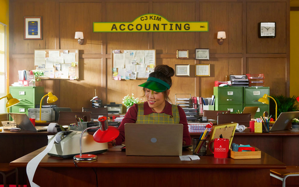 Woman working at a desk in a fictional accounting office for a Hiscox advertising campaign.