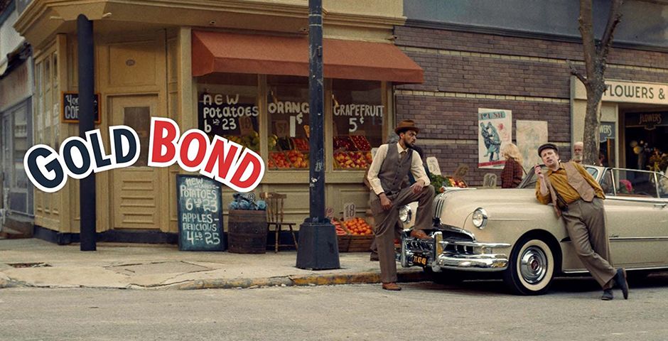 Gold Bond advertisement featuring two men beside a vintage car on a city street