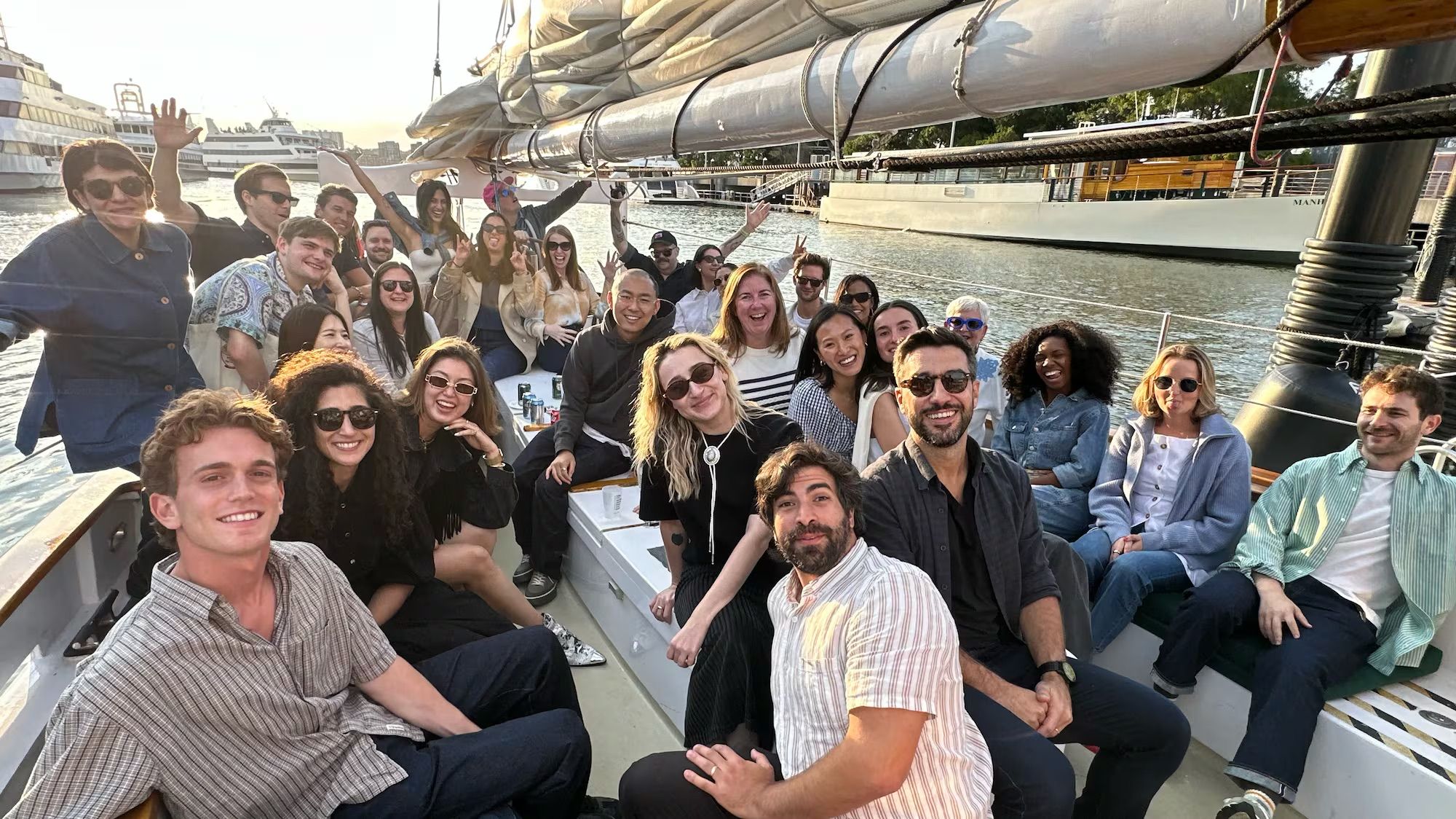Group of colleagues posing together on a boat during a team outing.