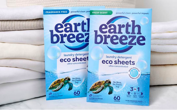 Earth Breeze eco sheets laundry detergent boxes in fragrance-free and fresh-scent varieties displayed on folded white towels.