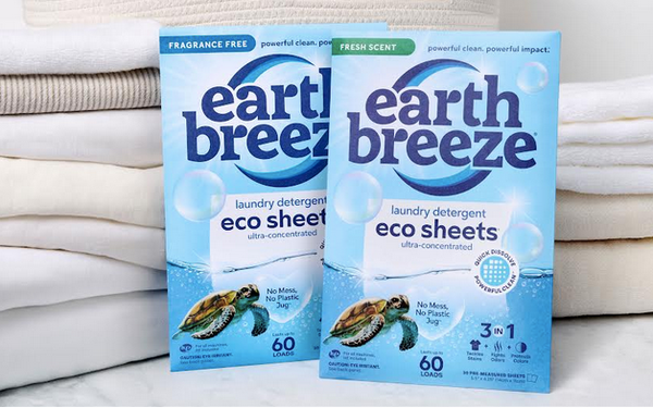Earth Breeze eco sheets laundry detergent boxes in fragrance-free and fresh-scent varieties displayed on folded white towels.