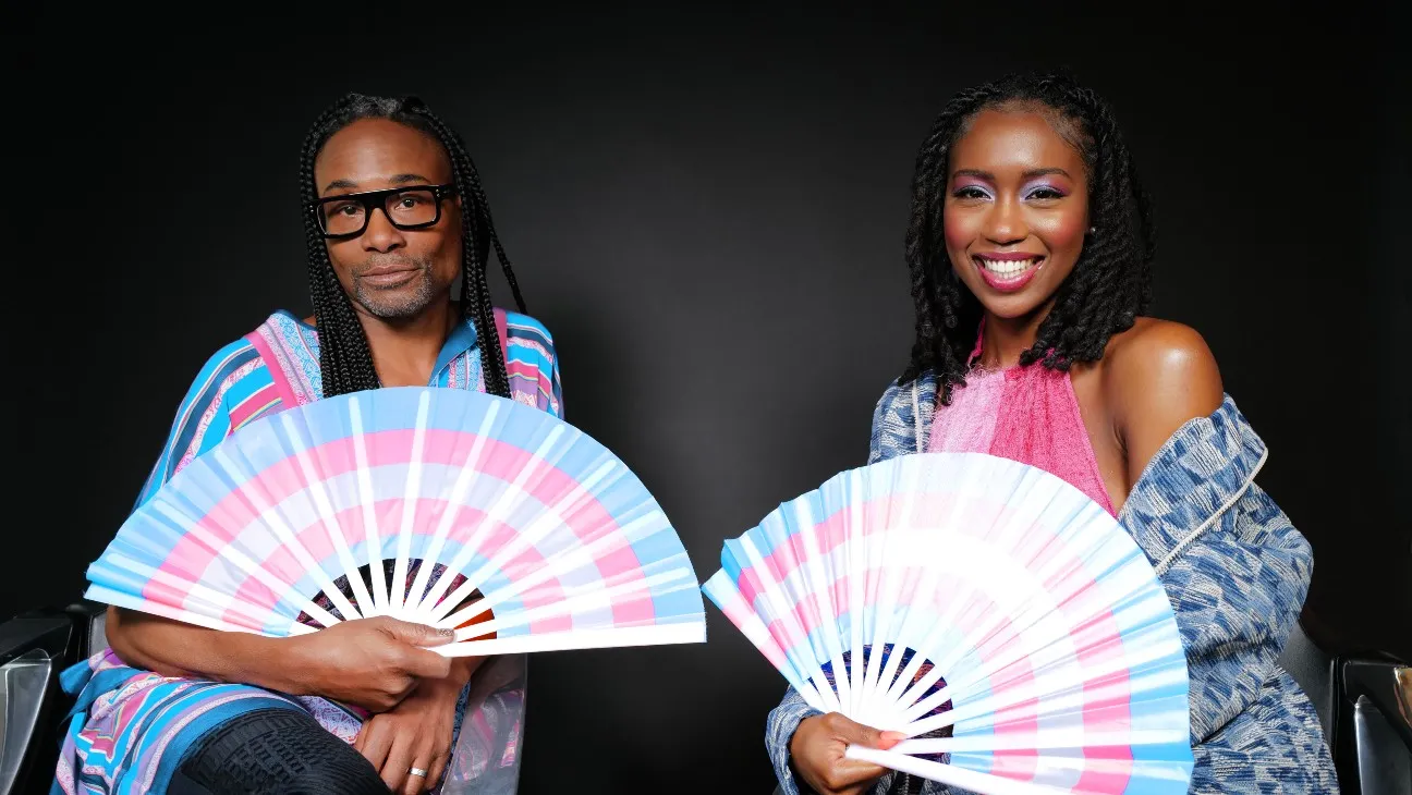 Two people holding transgender pride-colored fans in a visual from the Transphobe Takeover campaign.