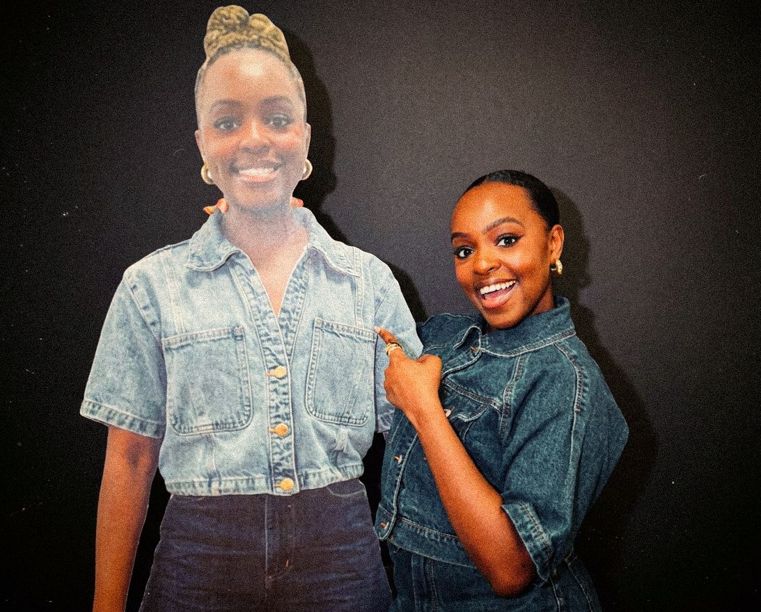 Terri & Sandy team member smiling and pointing to a life-size cutout of herself against a black background.