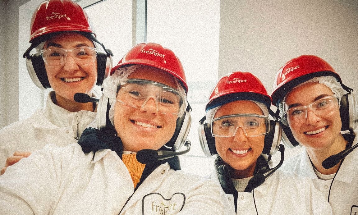 Freshpet team members wearing branded safety gear during a facility tour.