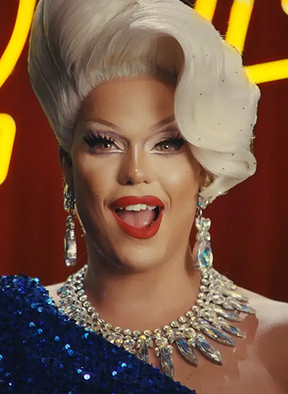 Nicky Doll wearing a dramatic white hairstyle, bold red lipstick, and jeweled accessories in Aspercreme pain relief campaign.