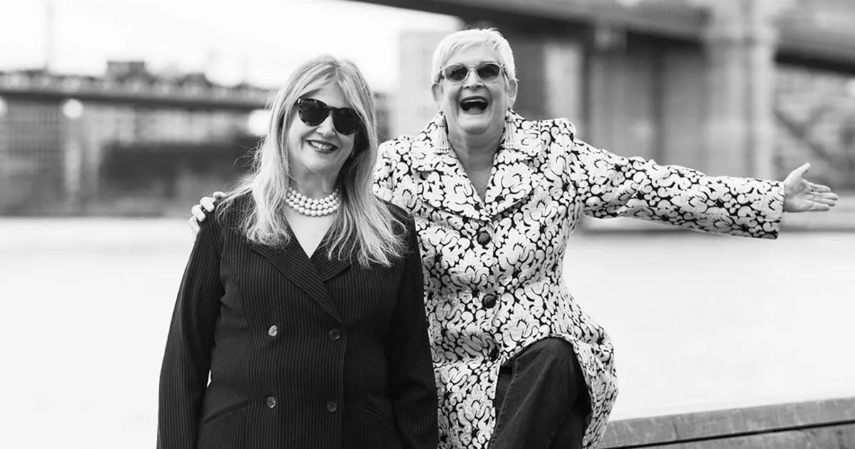 Terri and Sandy, cofounders of the Terri & Sandy creative advertising agency, smiling together in a black-and-white portrait.