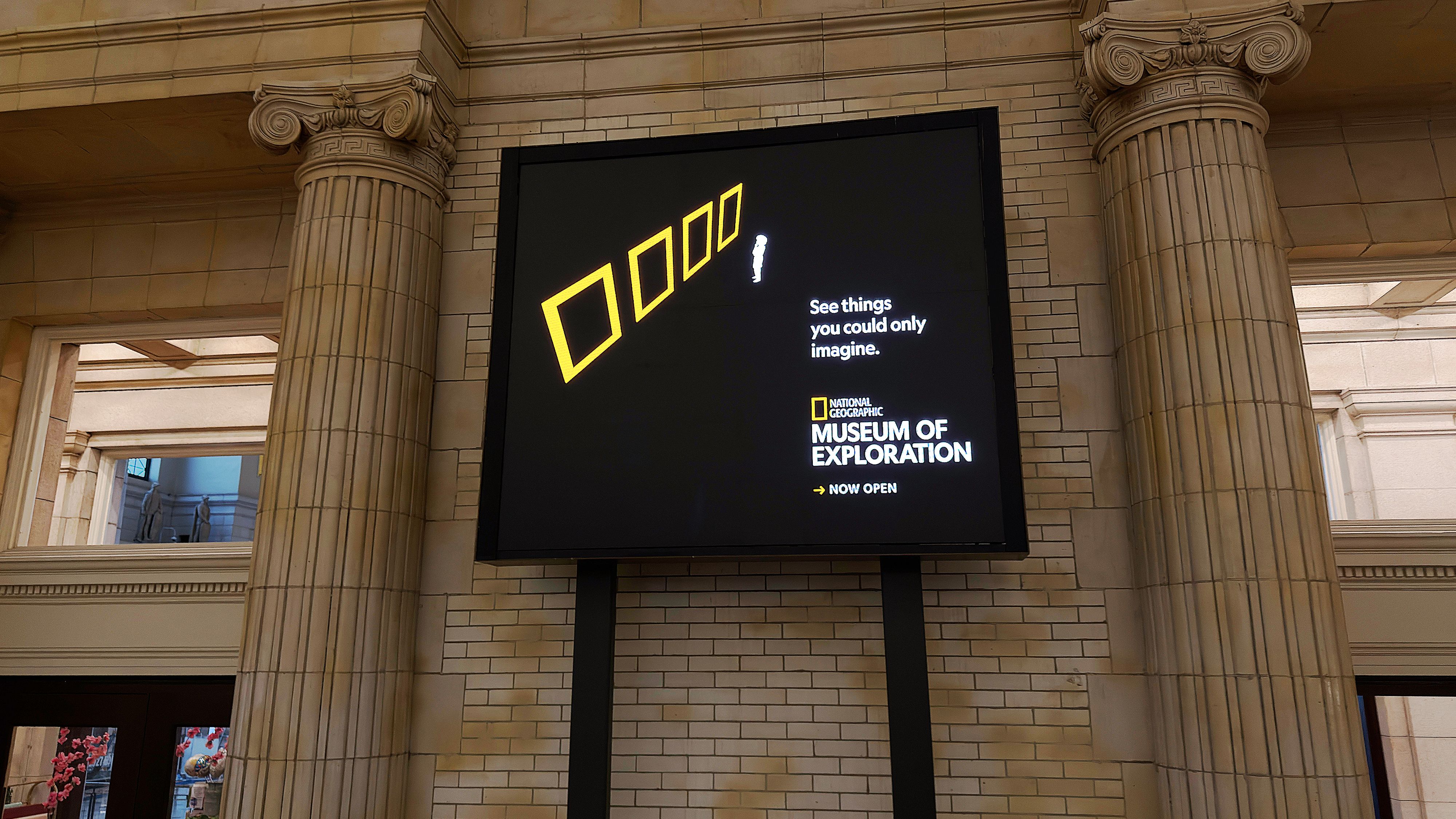 National Geographic Museum of Exploration digital display featuring yellow geometric frames and the slogan “See things you could only imagine.”