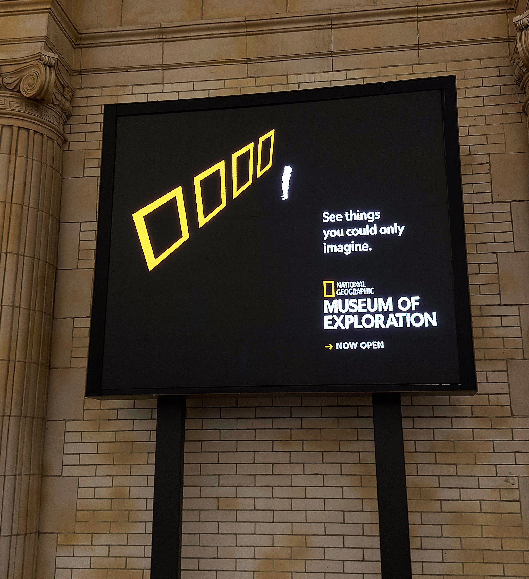 National Geographic Museum of Exploration digital display featuring yellow geometric frames and the slogan “See things you could only imagine.”