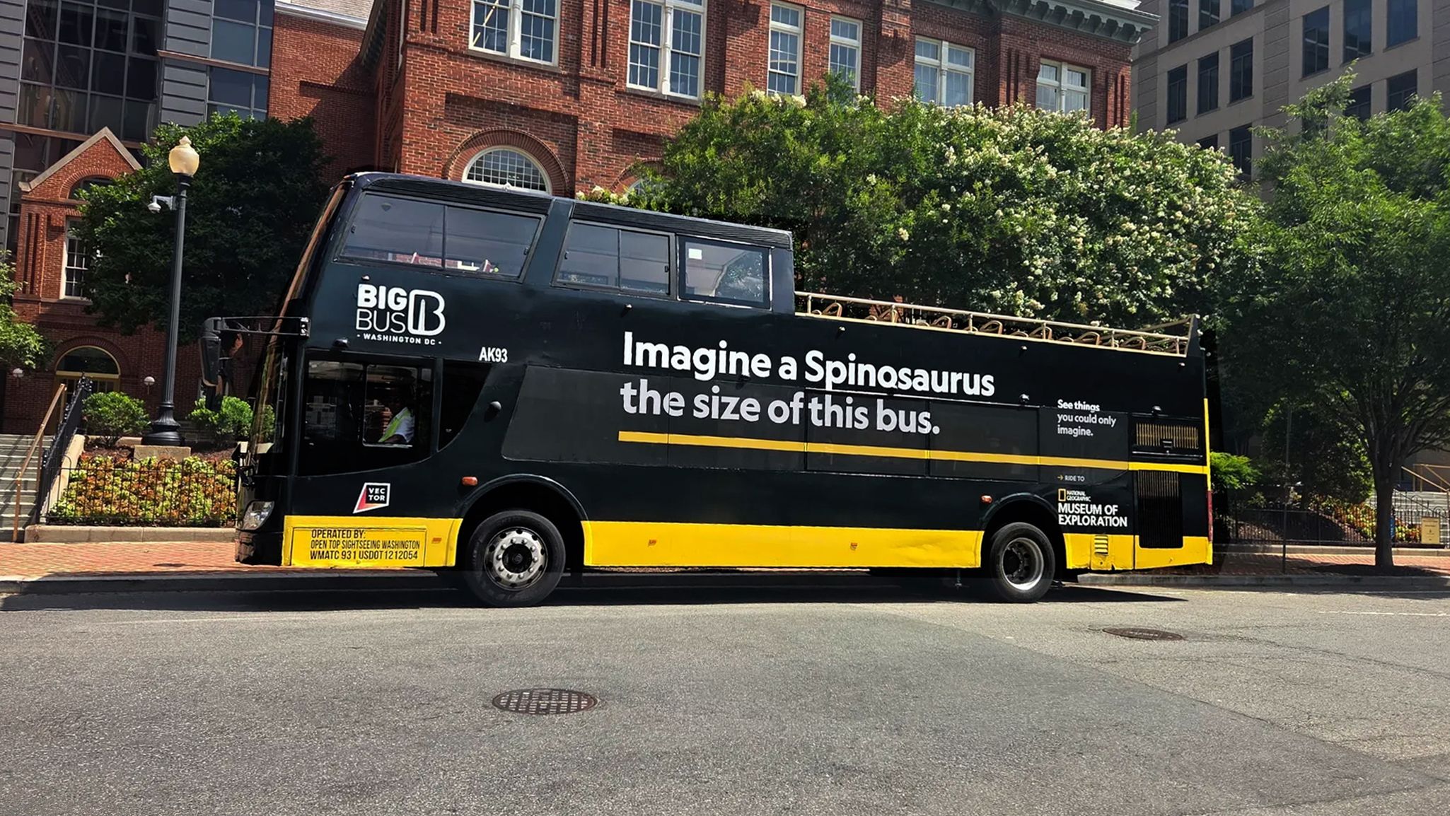 Big Bus in Washington, DC, wrapped in a National Geographic Museum of Exploration ad comparing its size to a Spinosaurus.