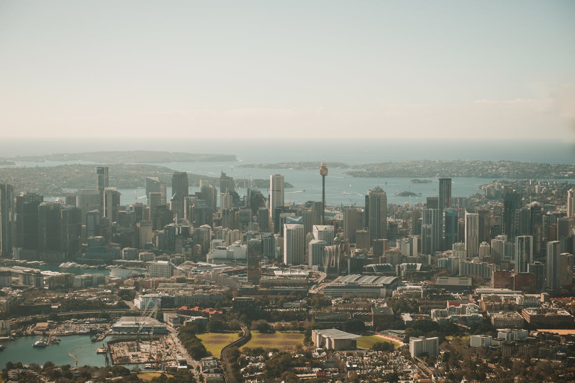 Aerial view of Sydney, Australia's urban skyline and harbour coastline on a clear, sunny day
