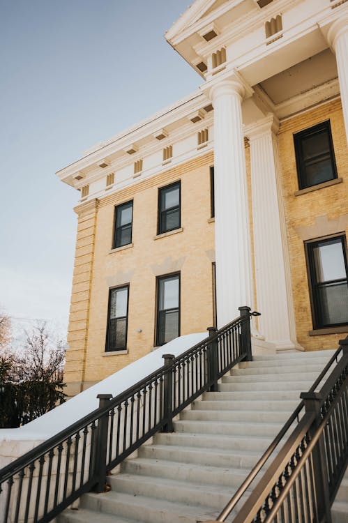 Exterior facade of a courthouse with classical white columns and stone steps leading to the entrance