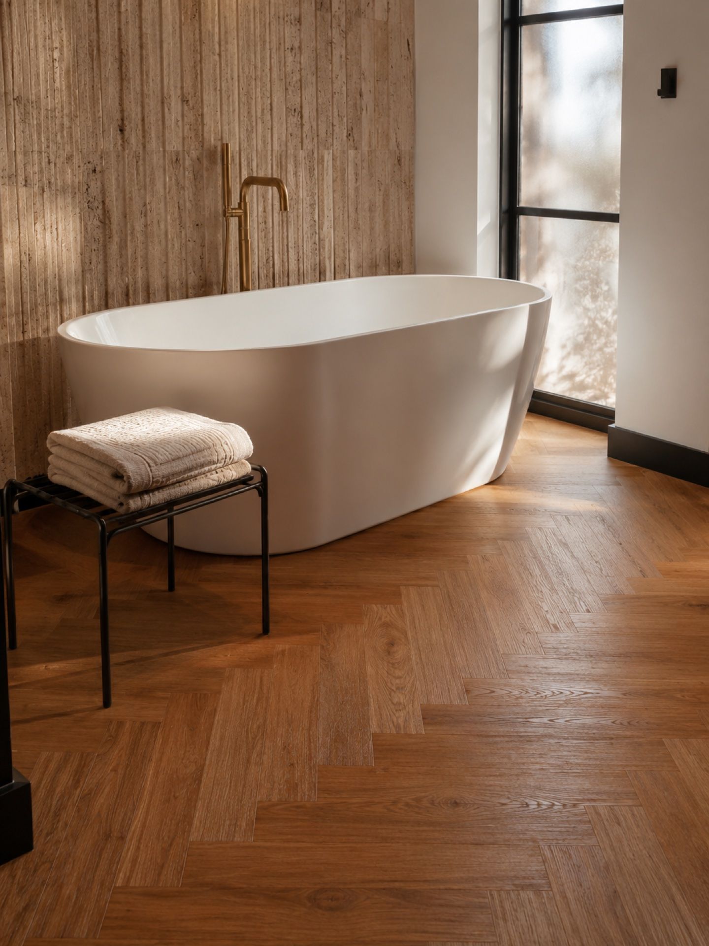 Salle de bain de la chambre — continuité du LVT chevron et baignoire îlot