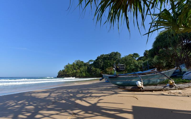 Fringed by a golden crescent beach and groves of towering coconut palms, the waters off the coast of Talalla sparkle in shades of turquoise, emerald and aquamarine.