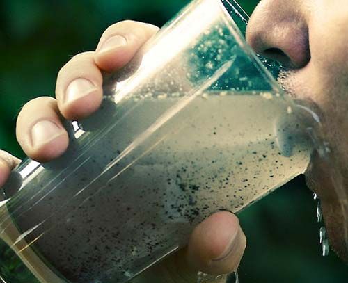Person drinks from glass of murky and dirty water - clearly contaminated
