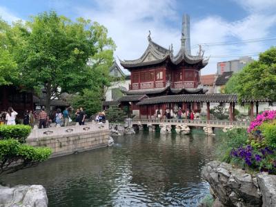 A two-storey pavilion with upturned eaves above a pond and stone bridge in Yu Garden