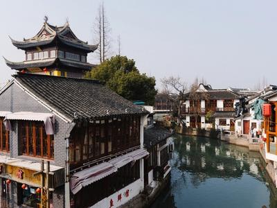 Old houses and a pagoda-roofed tower beside a canal in Zhujiajiao water town