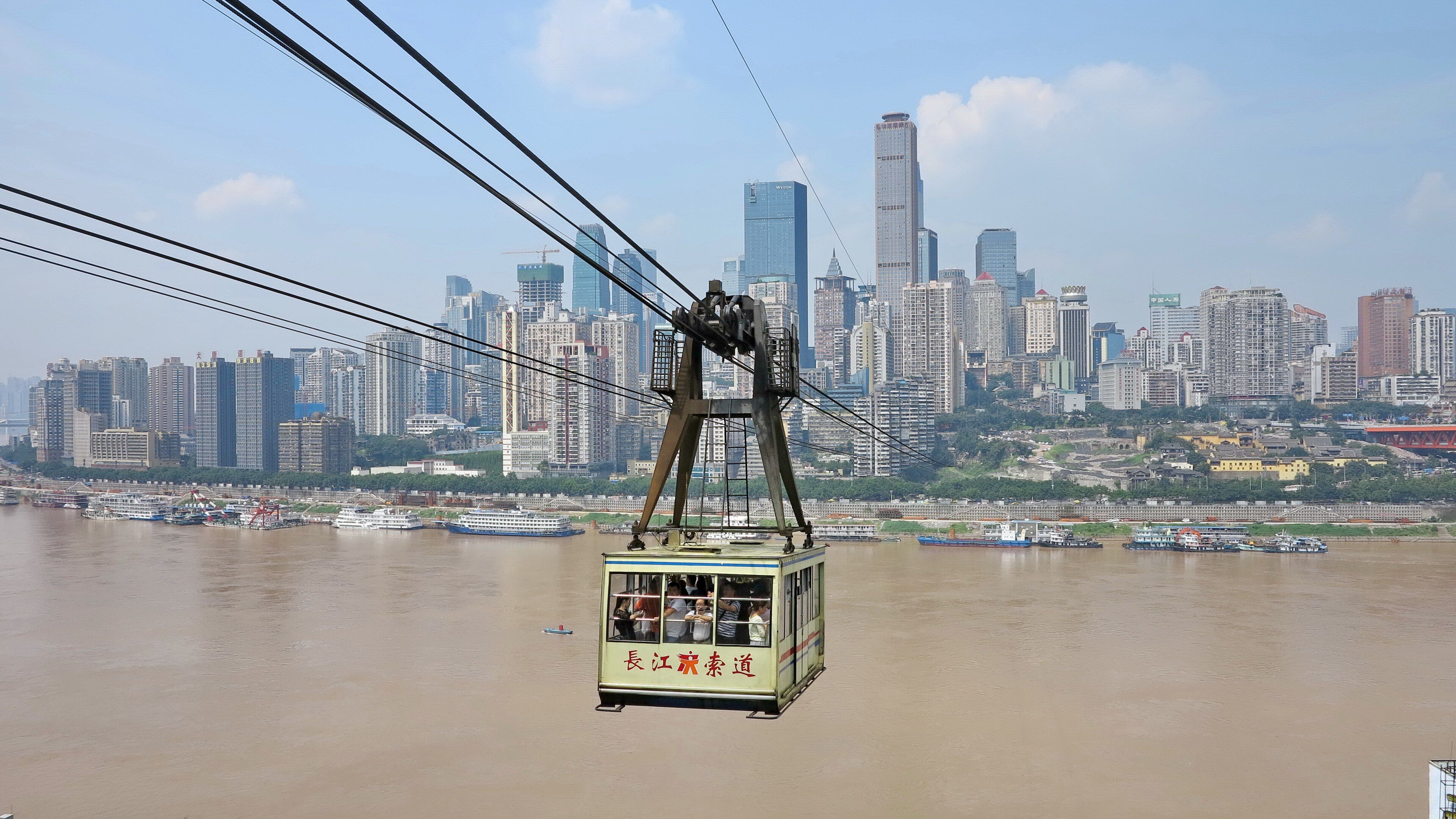 A Yangtze River Cableway cabin crossing the river, with the Yuzhong skyline behind it