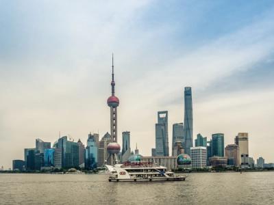 The Oriental Pearl Tower and the Lujiazui skyline across the Huangpu River, with a tour boat in the foreground