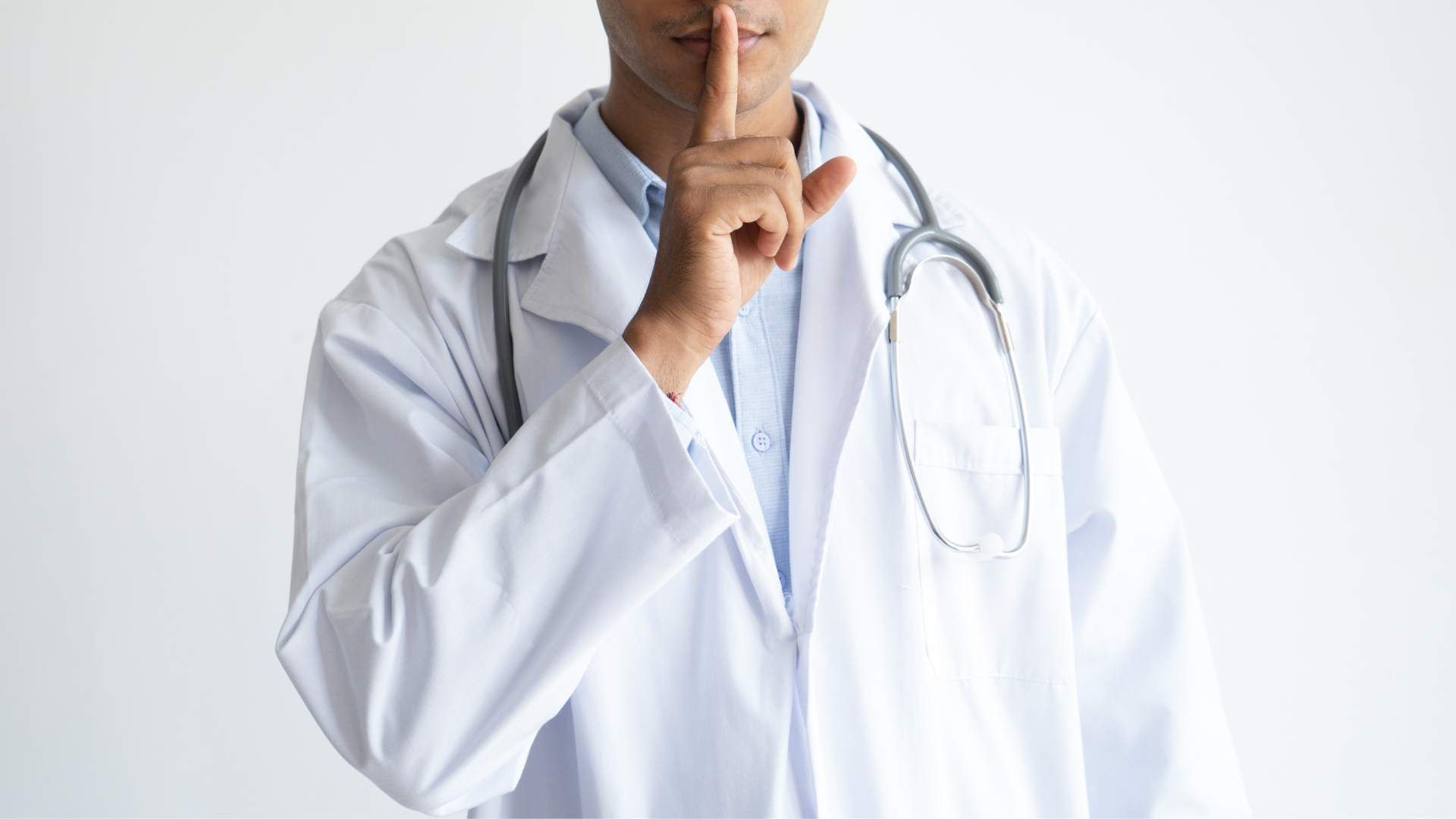 Bust of a Black or Brown person of color, in a healthcare attire with a stetoscope around their neck. Only half of their face is visible, and they have put a finger up to their mouth displaying "silence" or "secret".