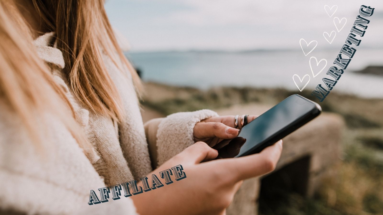 Femal upper body with long hair, hands holding an iPhone, background is a blurry landscape. Text: Affiliate Marketing. Animation of hearts flying out of the iPhone.
