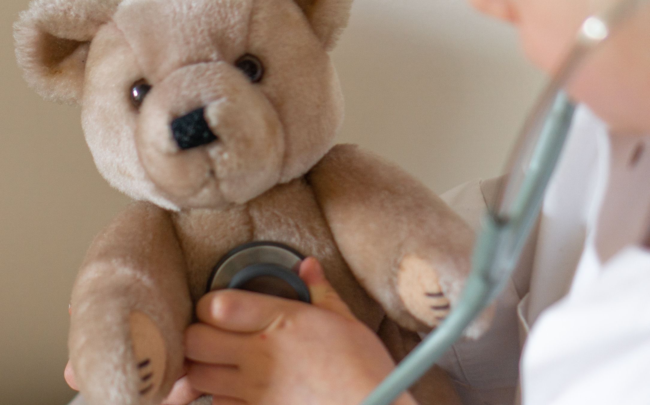 A teddy bear getting checked with a stethoscope
