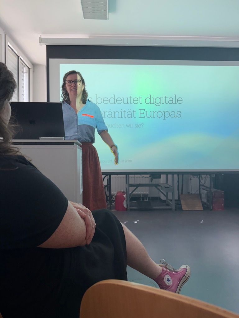 Lisa is standing behind a lectern and speaking. Behind her, you can see the presentation slide titled “What Does Europe’s Digital Sovereignty Mean, and Why Do We Need It?”