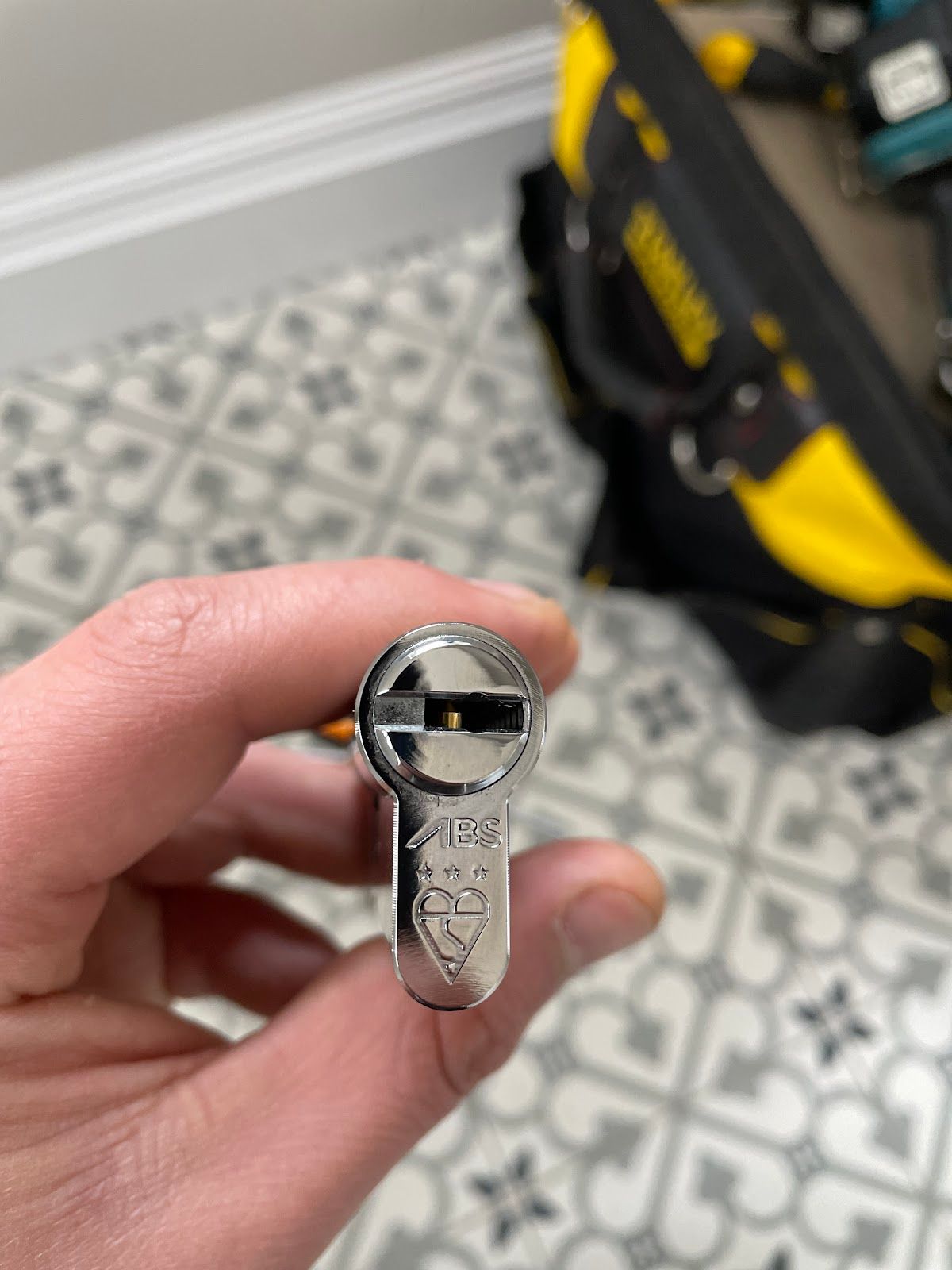 Euro cylinder lock held in hand showing signs of wear that indicate it needs replacing