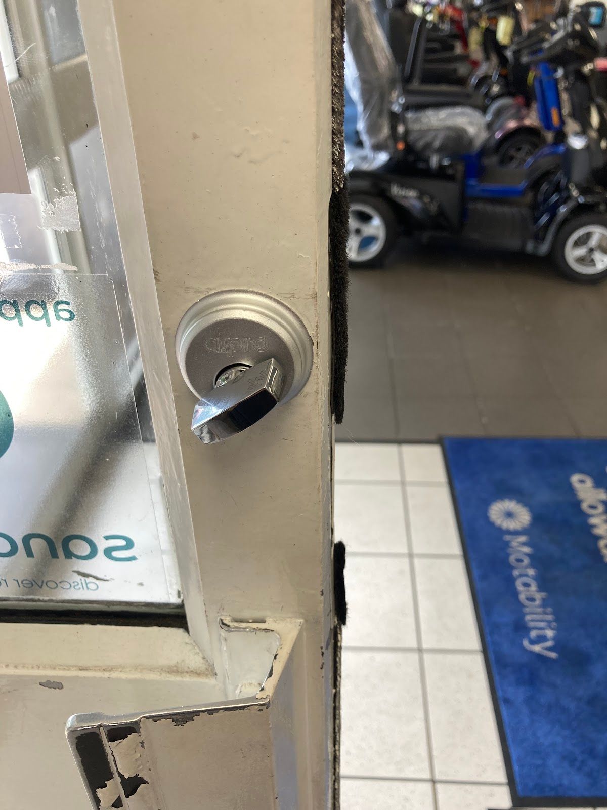 Worn lock cylinder on a commercial door showing the damage that occurs when door repairs are ignored