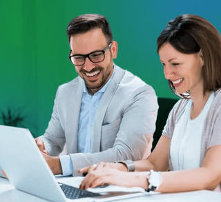 team members smiling at computer