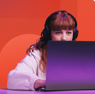 Women with headphones reviewing her laptop to learn what a digital asset management system is with a purple fade overtop with a geometric red background