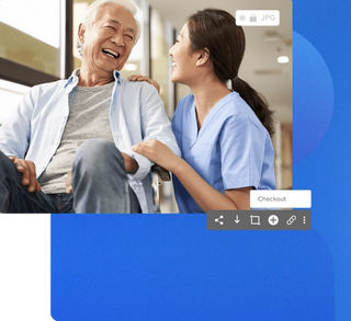 Older man in a wheelchair at a hospital with a nurse holding his arm and laughing with the patient with image details with a blue geometric background