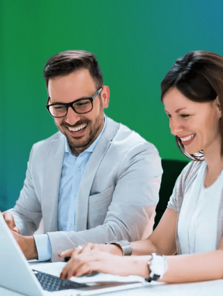 team members smiling at computer