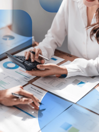 Digital asset management (DAM) trends reports laid out on a desk with women's hand holding a pen pointing at paper, second women holding a calculator looking at a document with blue overlay