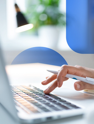 A person working on a laptop with a blurry office space in the background