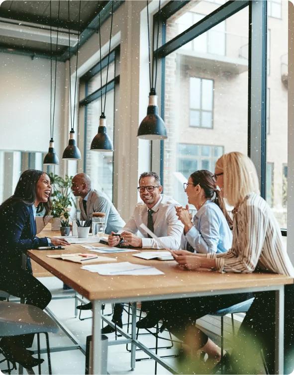 Colleagues laughing at a conference table