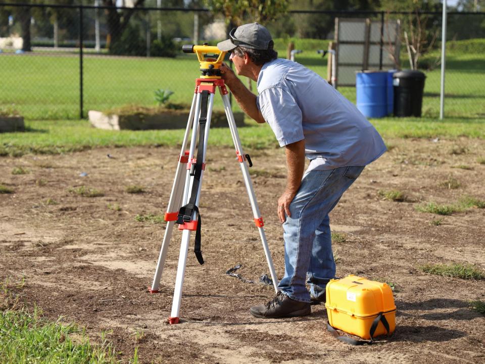 Profissional realizando levantamento topográfico em um terreno