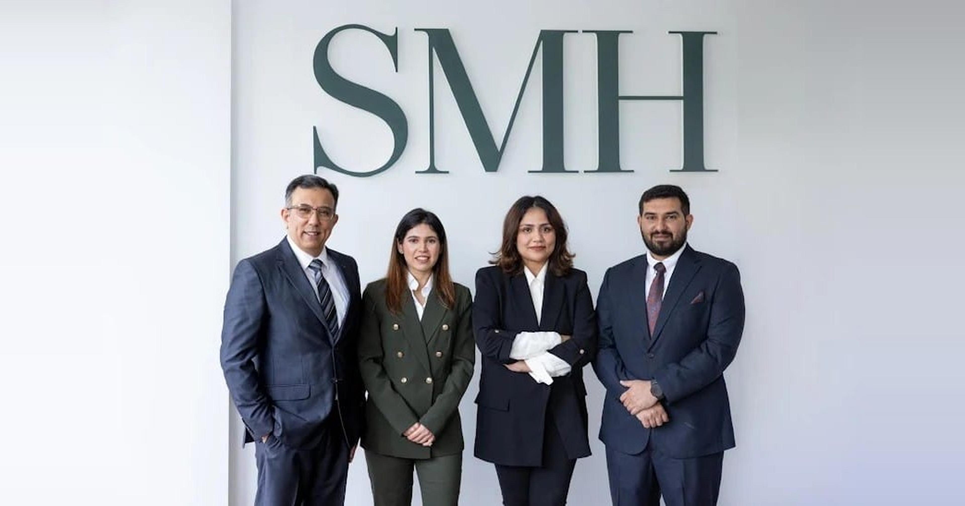 The SMH Group team standing in front of the SMH sign