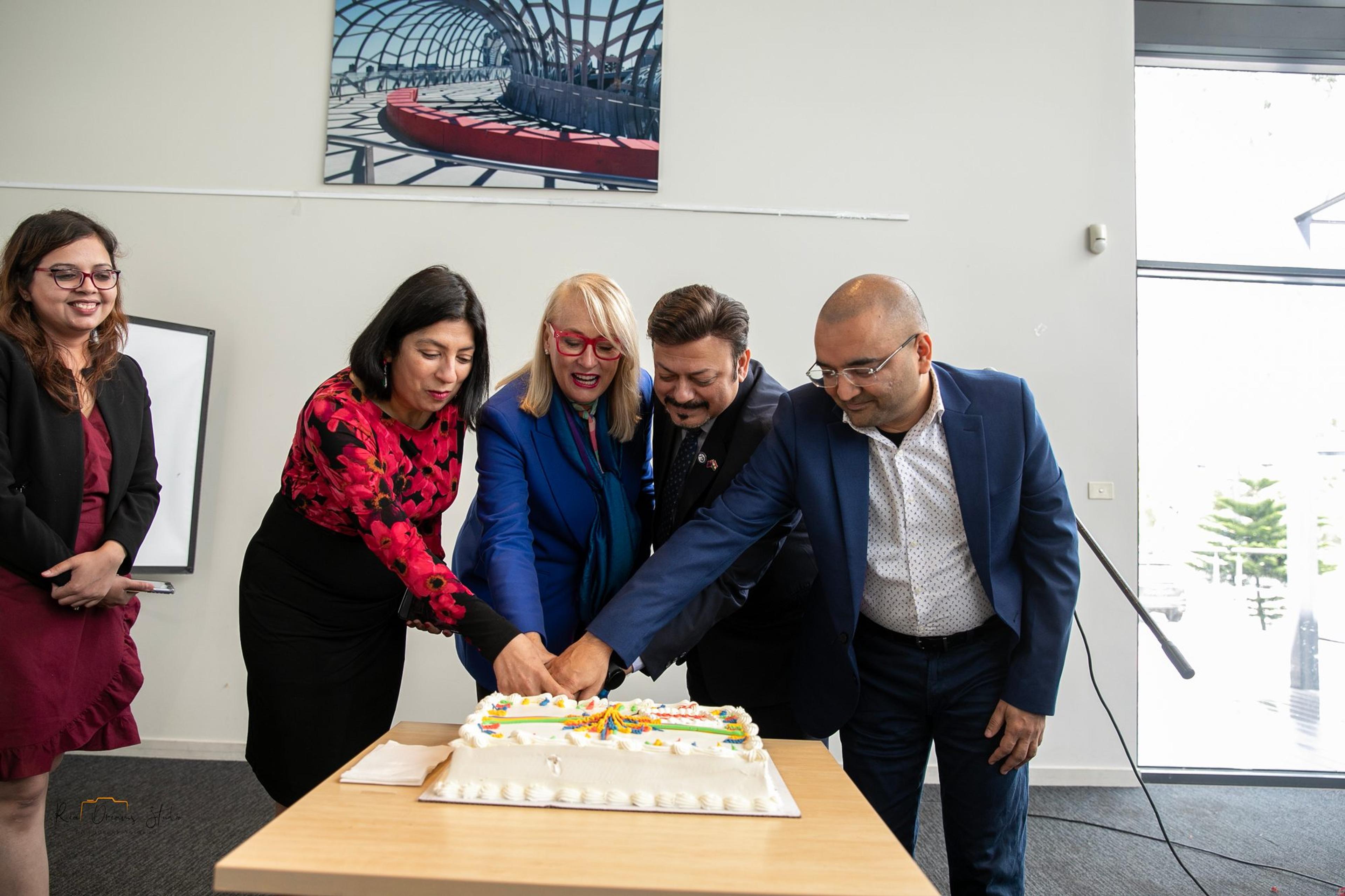 Four guests cut the Happy Diwali cake