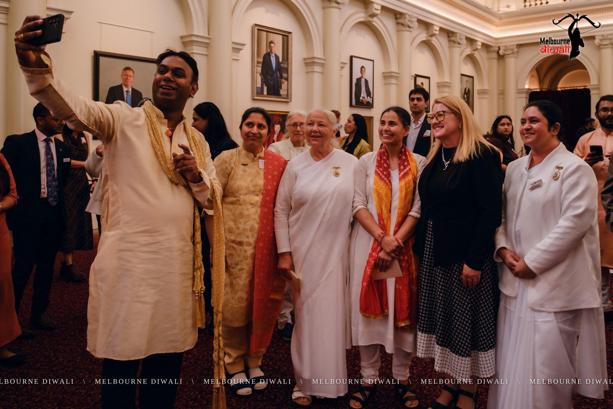 Guests, among them Brahma Kumaris sisters, gather for a group selfie