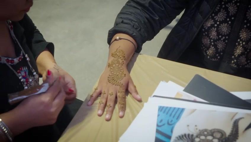 A festival-goer having mehndi applied to her hand at Melbourne Diwali 2023
