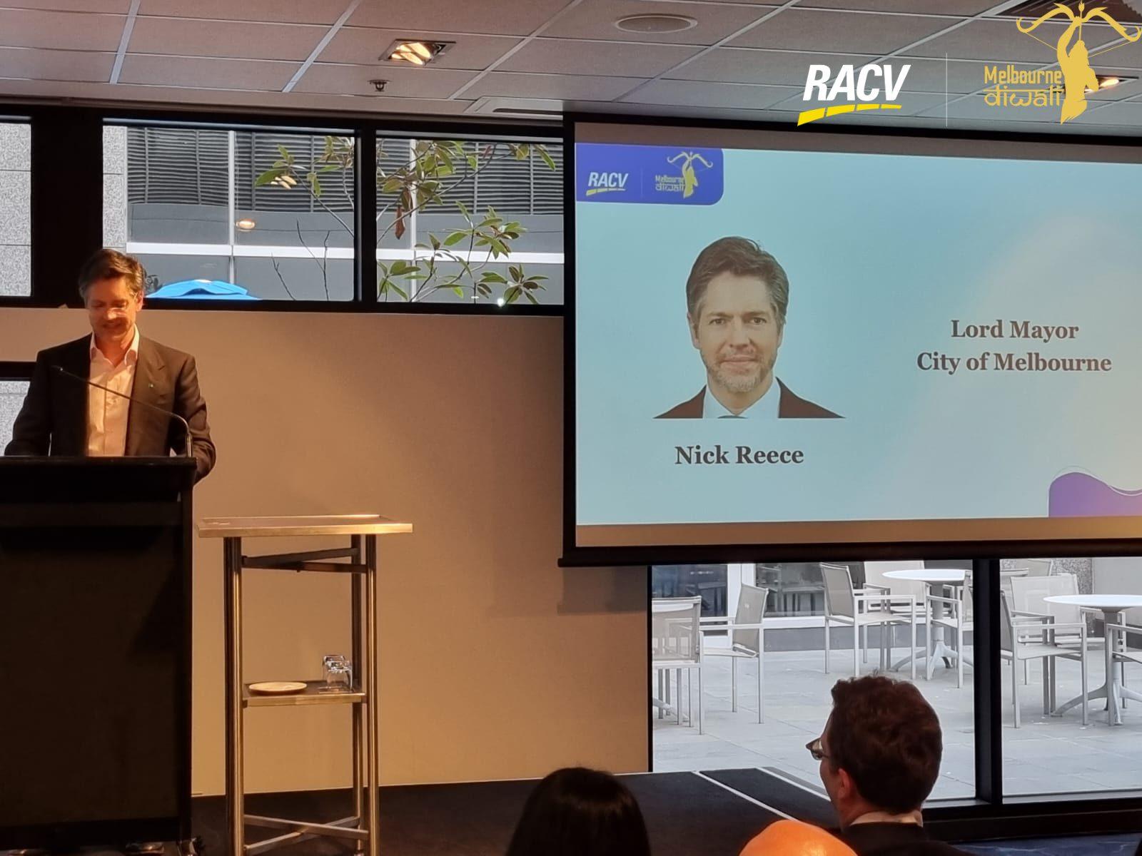 Lord Mayor Nick Reece speaks at the lectern beside the slide 'Lord Mayor, City of Melbourne'