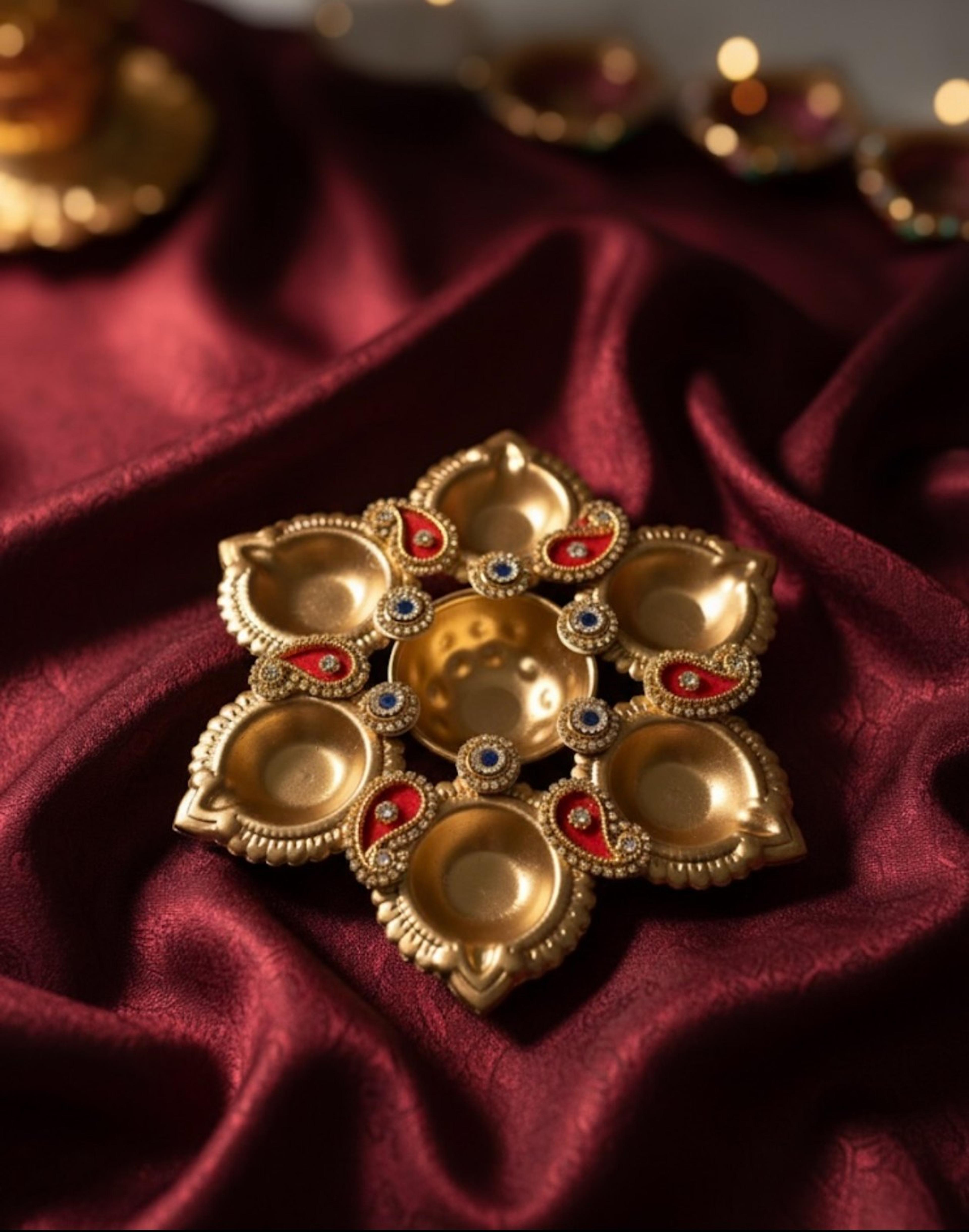 Brass diya on maroon satin