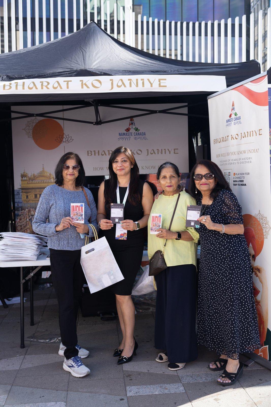 Visitors with quiz postcards and giveaway bags at the Bharat Ko Janiye stall