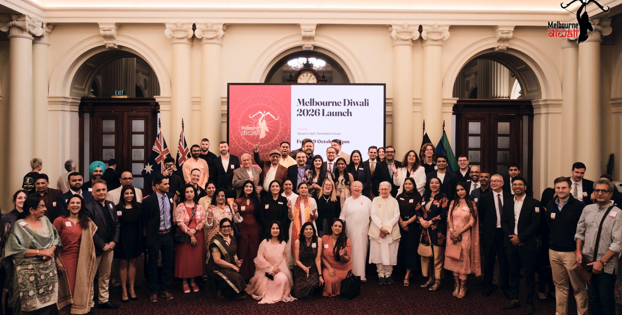 The group photograph: guests and speakers together in front of the Melbourne Diwali 2026 Launch screen in Queen's Hall