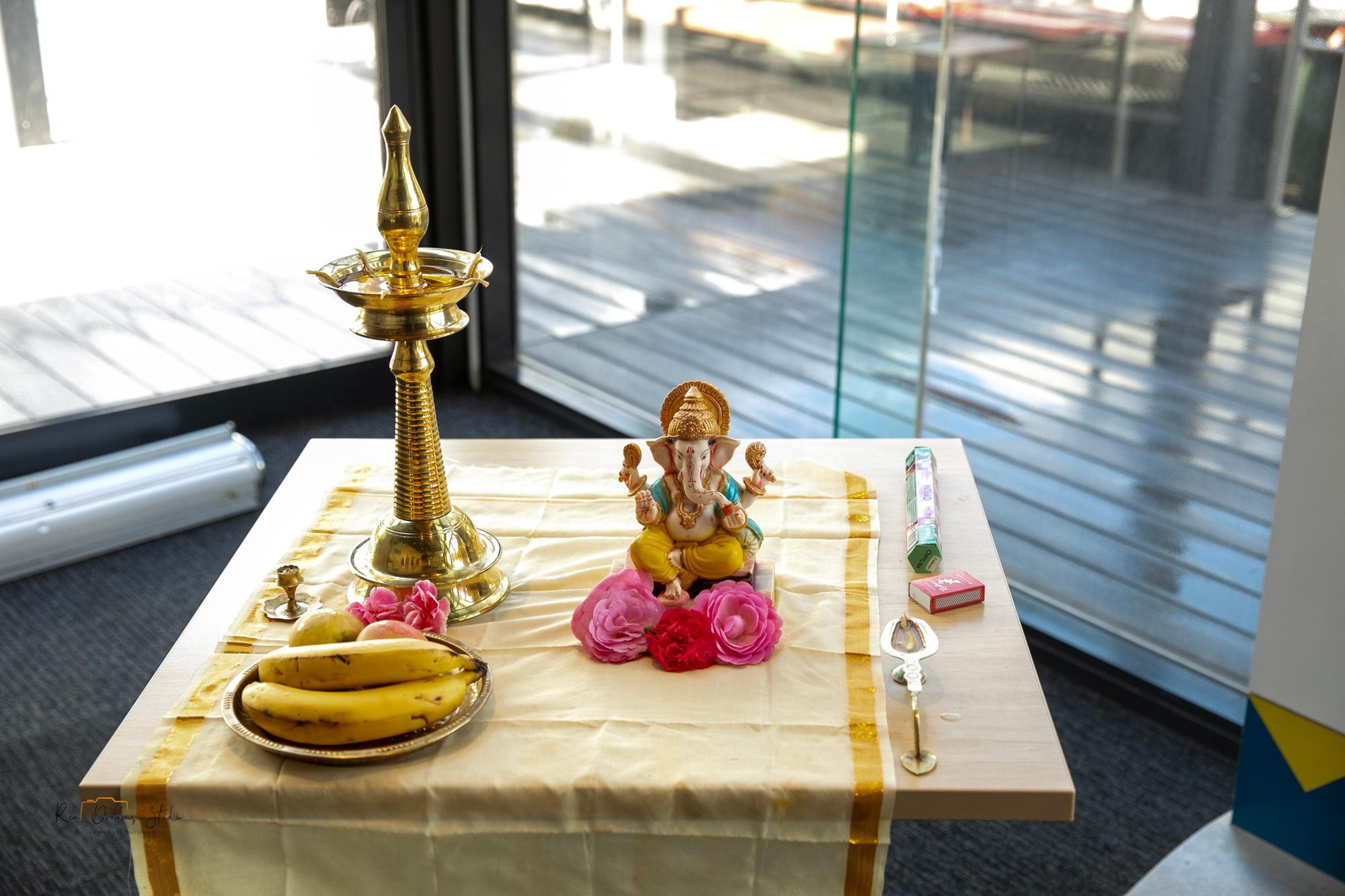 The ceremonial table set with a brass lamp, a Ganesh figure, flowers and fruit