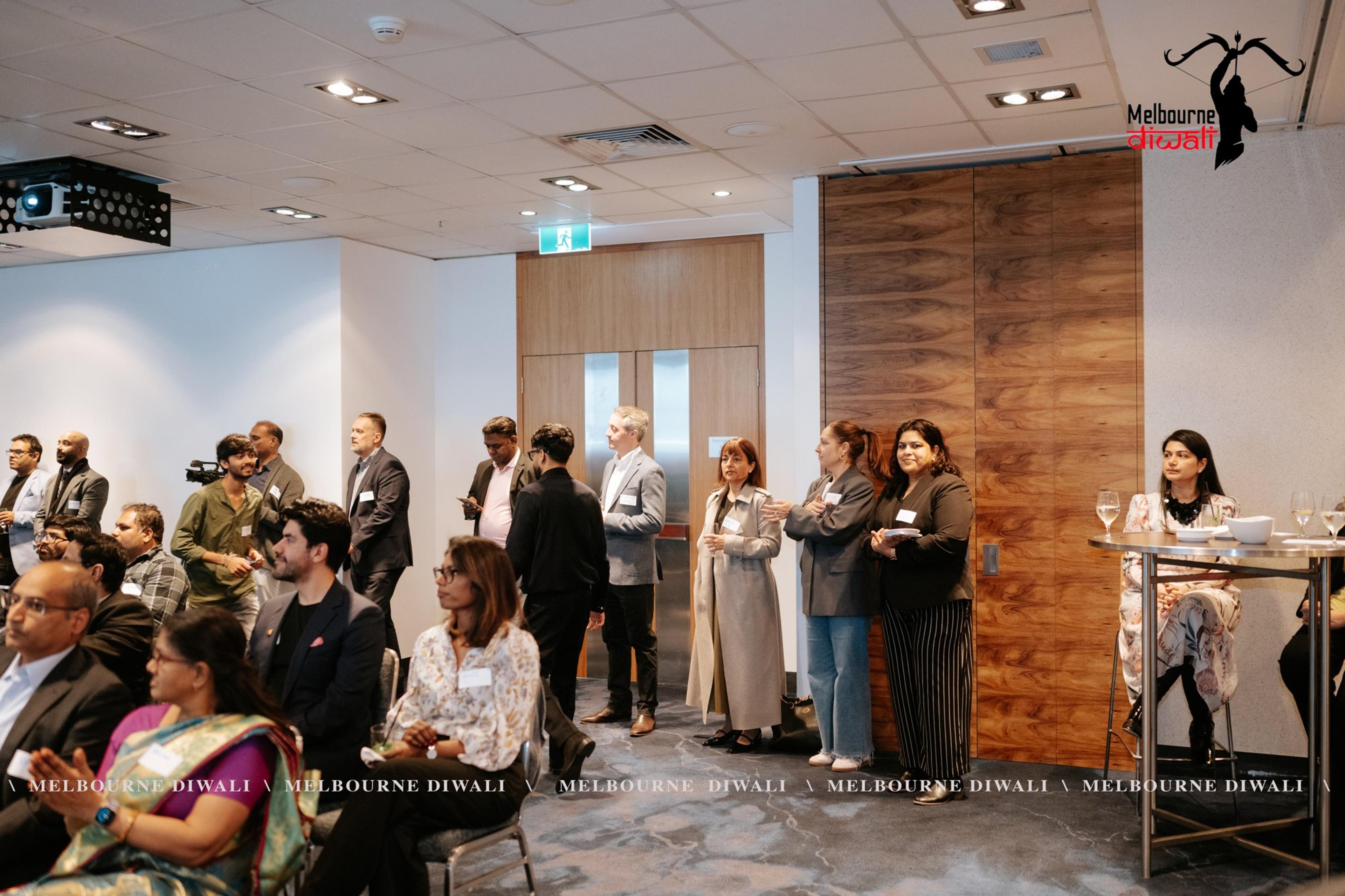 Guests stand at the back of the room during the programme