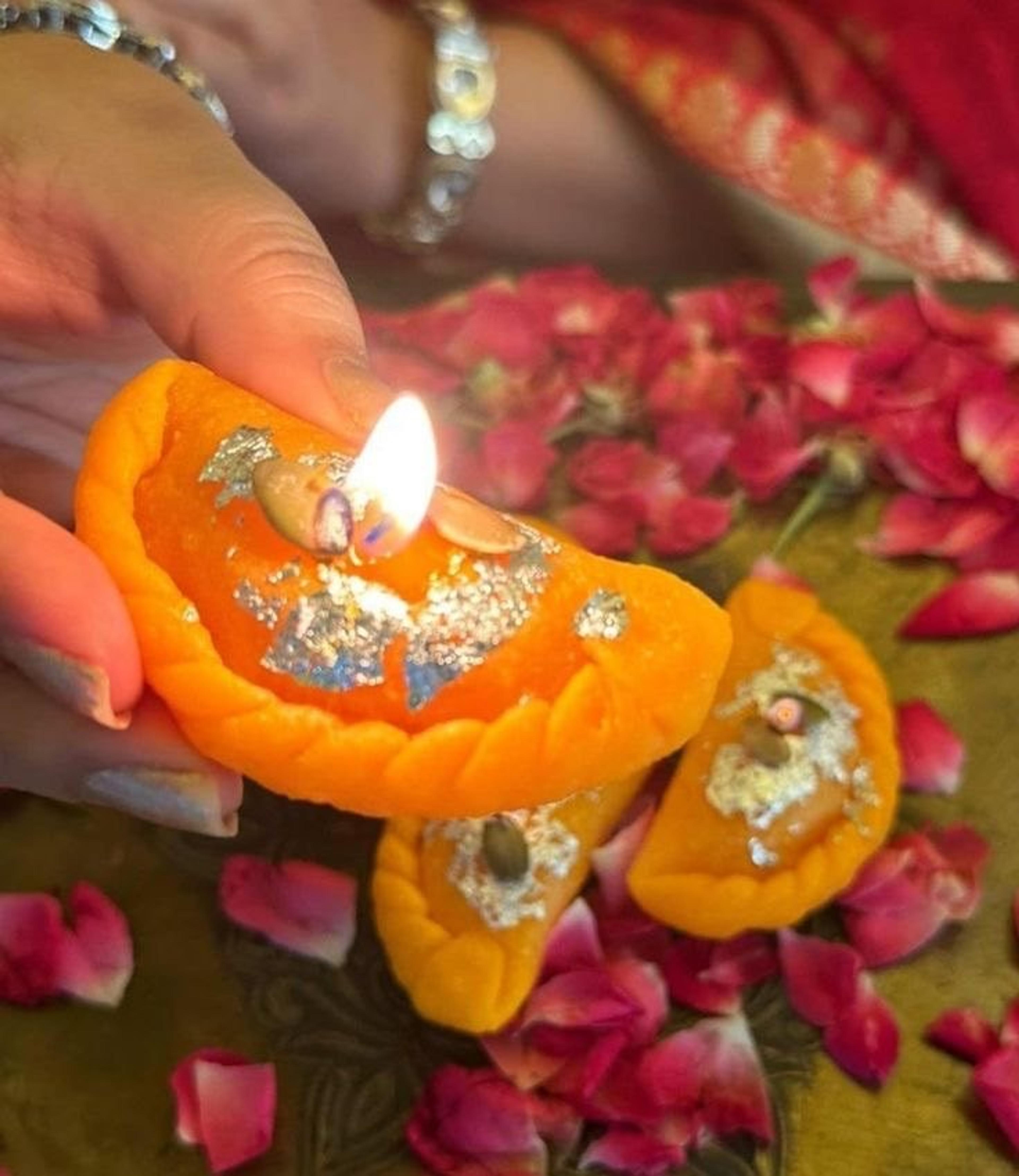 Decorated diya among rose petals