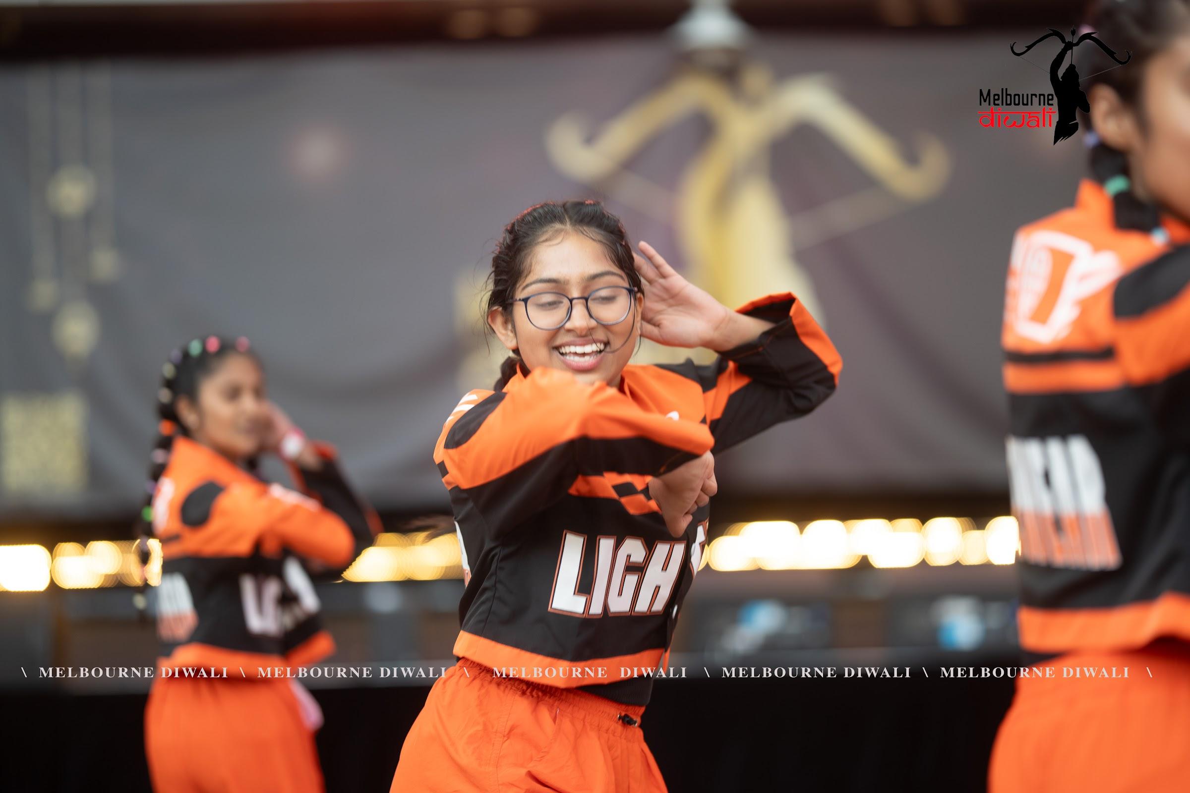 A young performer smiles mid-routine during a street dance set at Melbourne Diwali 2025