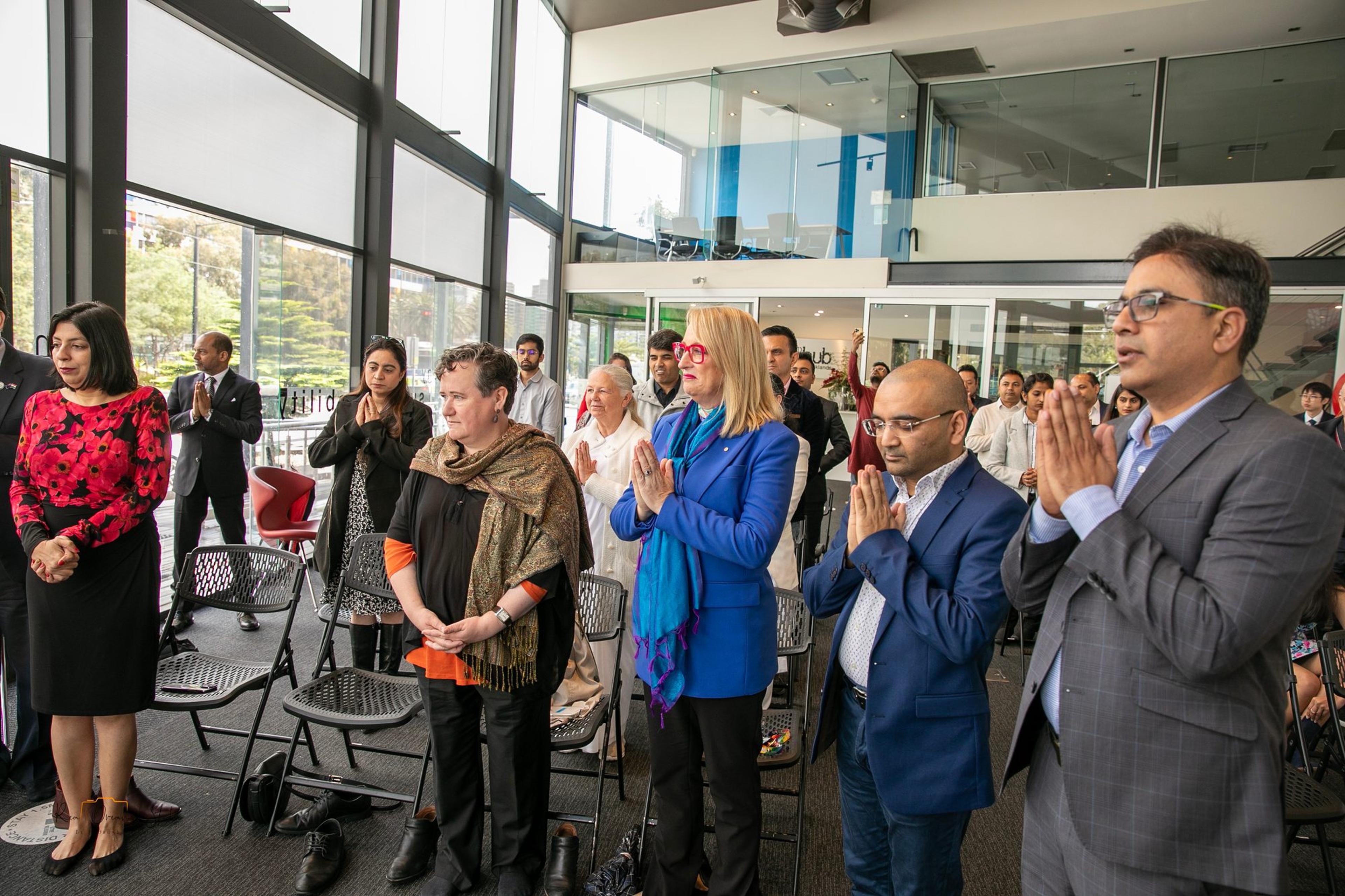 Guests stand with hands joined after the lamp lighting
