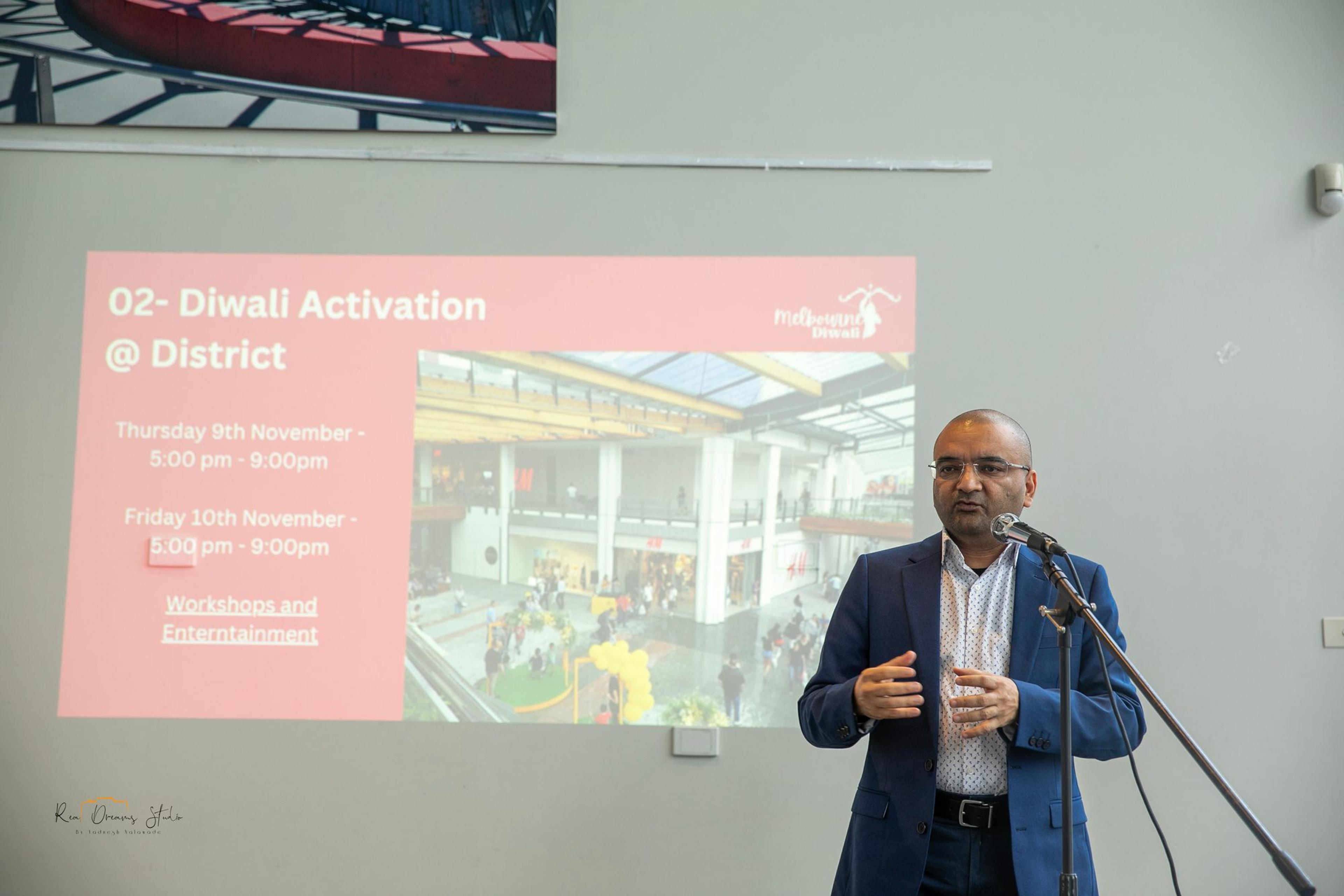 A presenter beside the slide for the Diwali Activation at The District, Thursday 9 and Friday 10 November